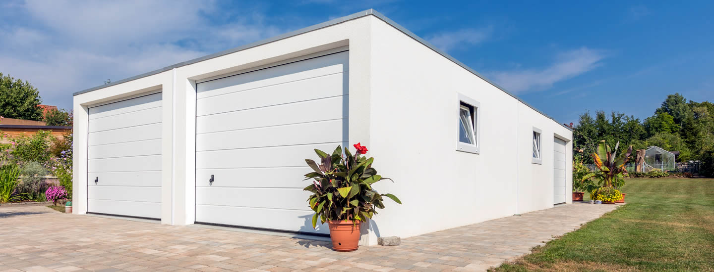 Doppelgarage aus Beton mit Anbau und Fenster