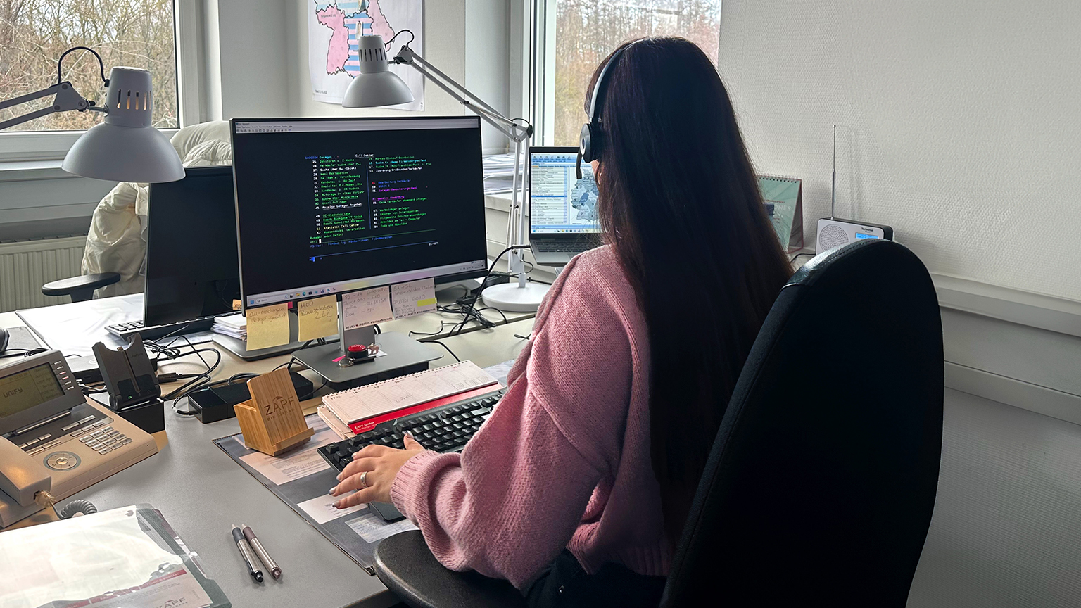 Mitarbeiterin mit Headset am Arbeitsplatz im Kundenservice der Firma ZAPF.
