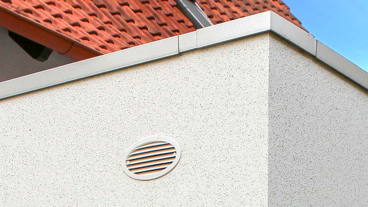 Detailansicht einer Lüftungsöffnung an der Außenwand einer Fertiggarage mit Flachdach