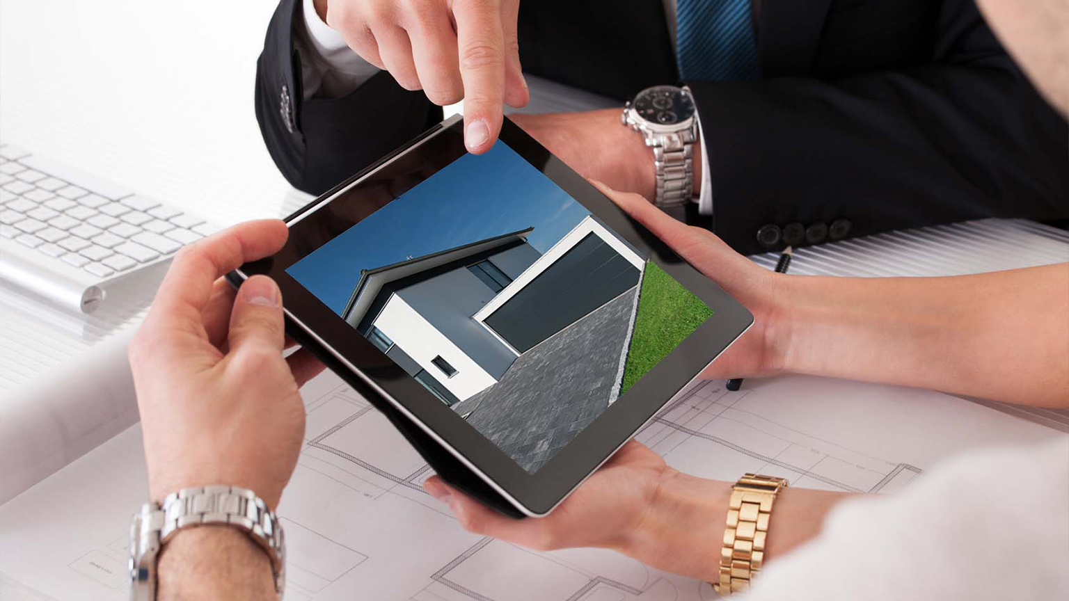 Tablet mit 3D-Visualisierung einer modernen Garage wird bei Beratungsgespräch von zwei Personen betrachtet.