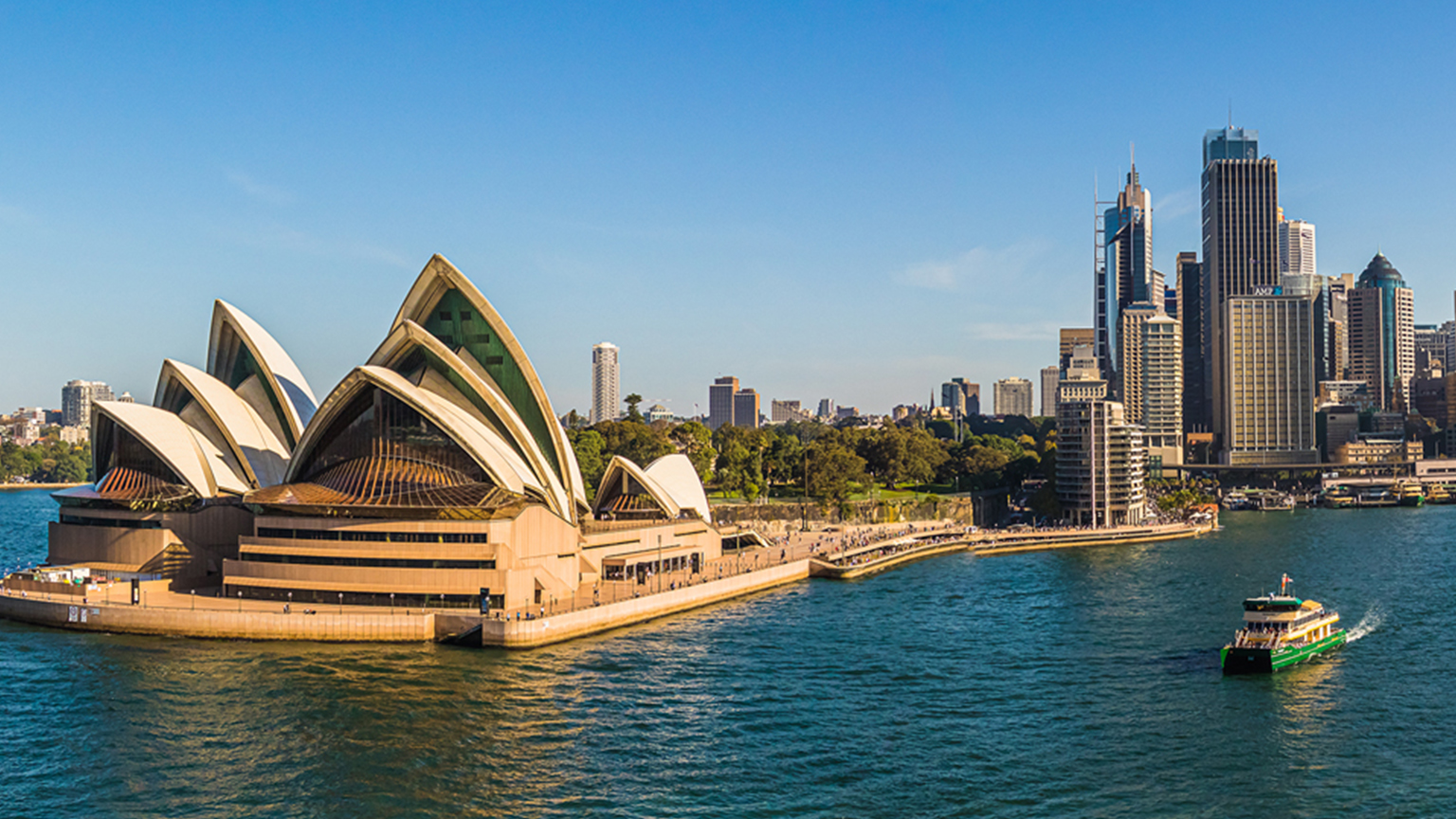 Weitwinkelaufnahme des Sydney Opera House mit dramatischem Abendhimmel und Menschen auf der Treppe