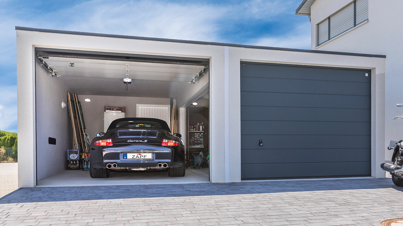 ZAPF Doppelgarage mit einem geparkten Porsche Carrera S und geschlossener Garagenseite nebenan.