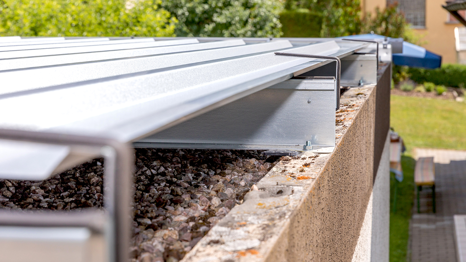 Detailaufnahme eines Flachdachs mit Kies und modernem Metallrandabschluss auf einer ZAPF Fertiggarage.
