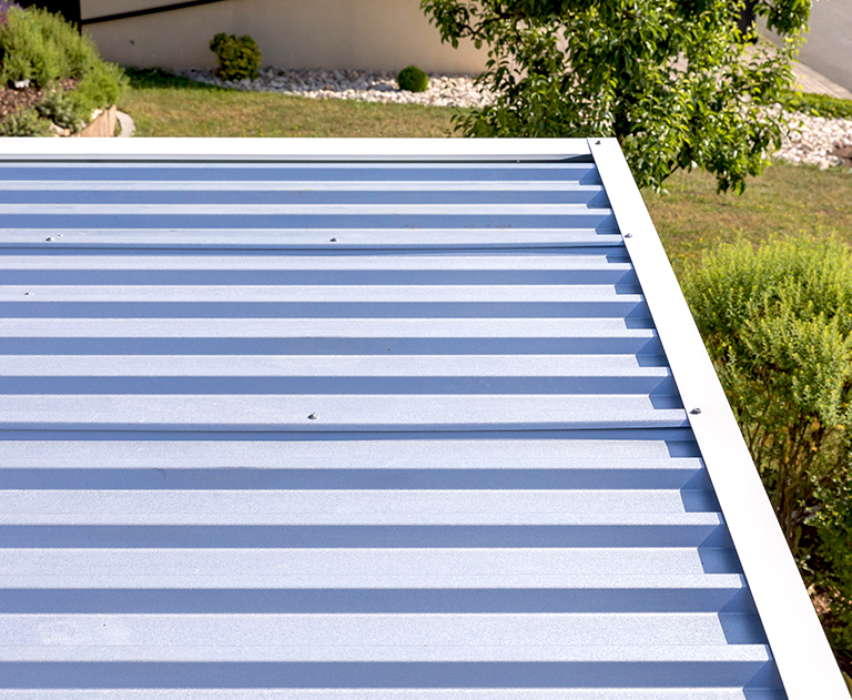 Close-up of a blue trapezoidal sheet metal roof on a modern prefabricated garage.
