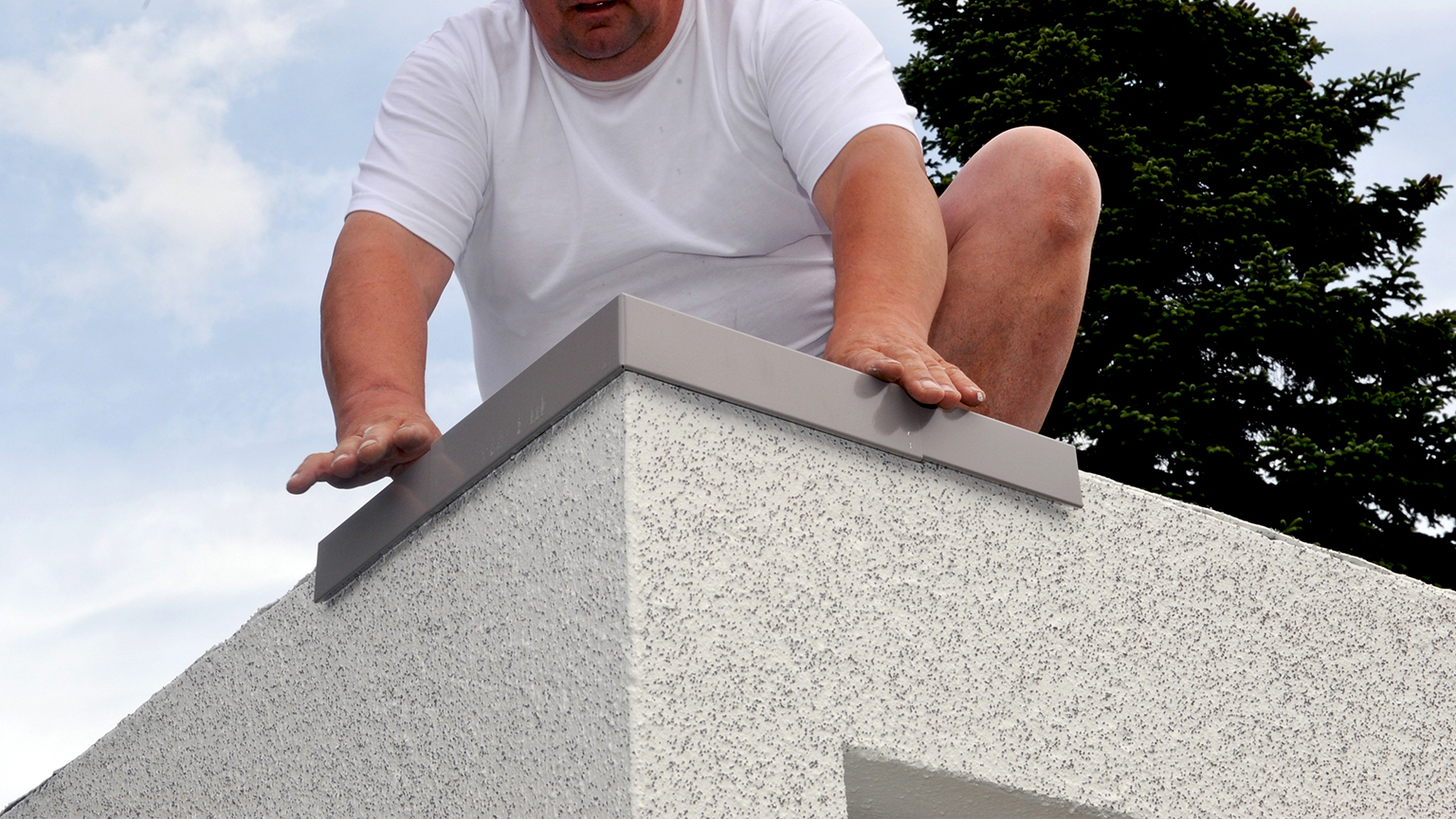 zapf_blog_beitragstitel_dach Handwerker montiert Attikaabdeckung auf Garagendachkante.