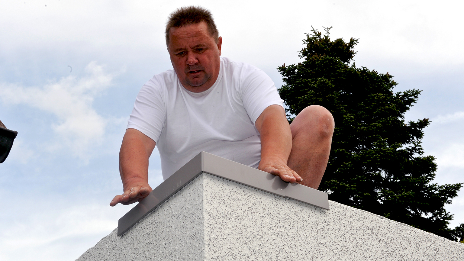 zapf_blog_beitragstitel_fruehlingsfit Handwerker montiert Dachabschlussleiste auf einer Garagenecke.