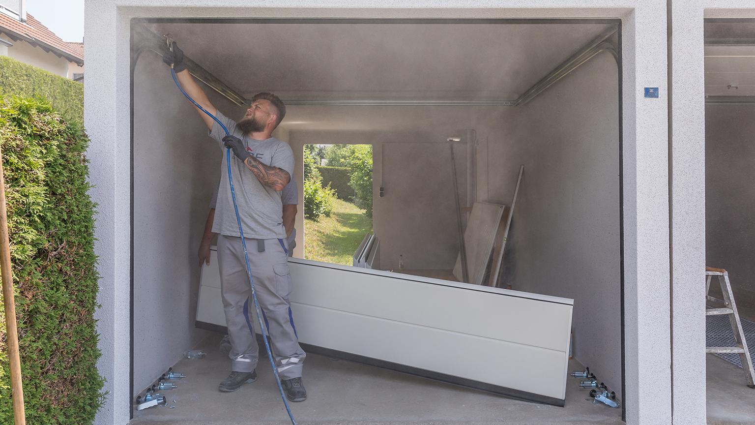 zapf_blog_beitragstitel_garagencheck3 ZAPF Monteur prüft Toranlage einer Fertiggarage während des Garagenchecks