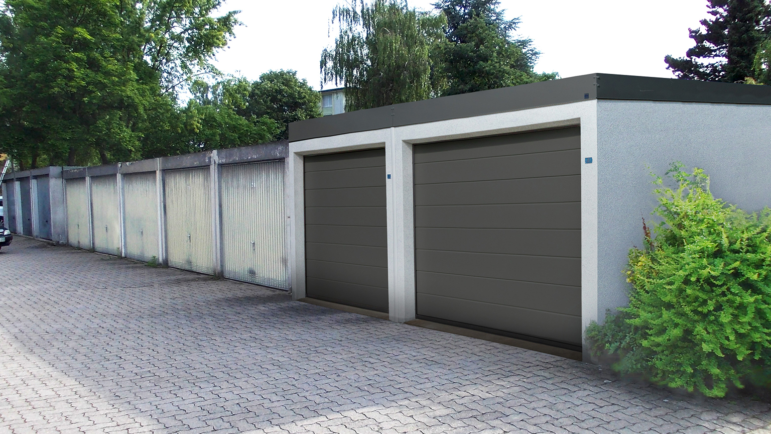 zapf_blog_beitragstitel_gemauert Doppelgarage mit modernen grauen Sektionaltoren vor einer Reihe älterer Garagen.