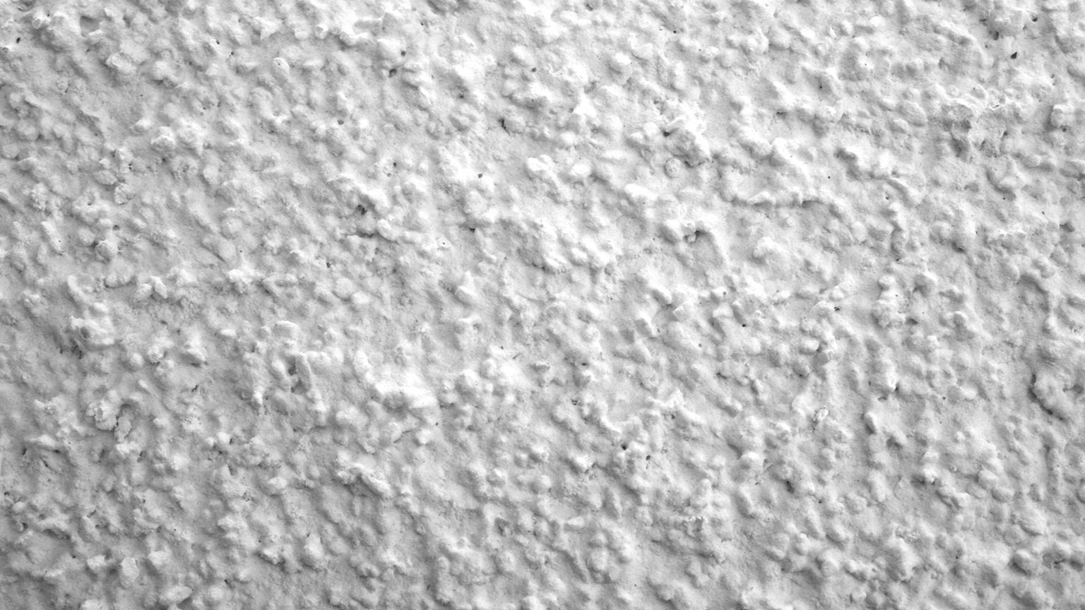 zapf_blog_beitragstitel_guenstiger Nahaufnahme einer weißen, grobkörnigen Putzoberfläche.