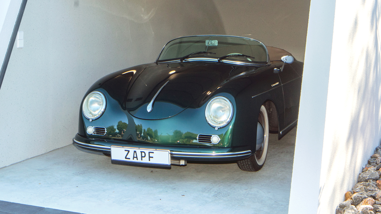 Klassischer grüner Sportwagen steht in einer modernen Garage.