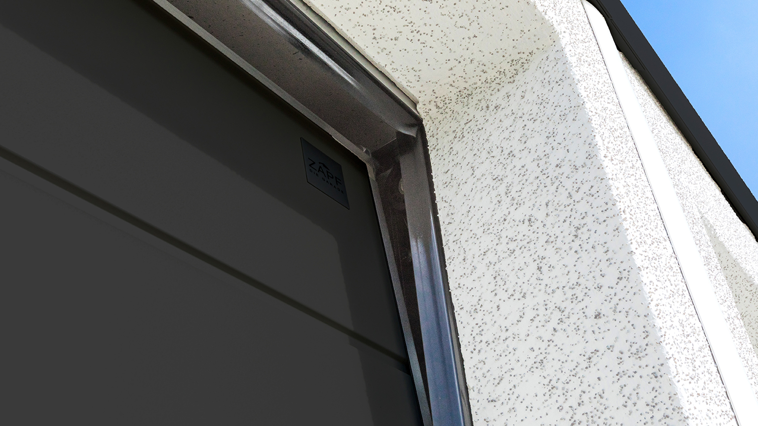 Nahaufnahme eines Garagentors mit seitlicher Dichtung und Putzfassade.