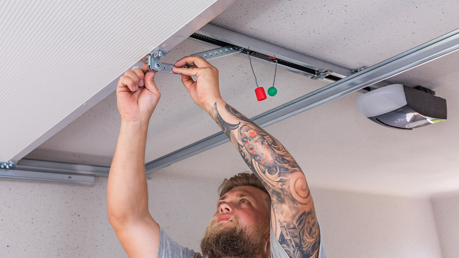 zapf_blog_beitragstitel_torantrieb Handwerker montiert Garagentormechanismus an der Decke.