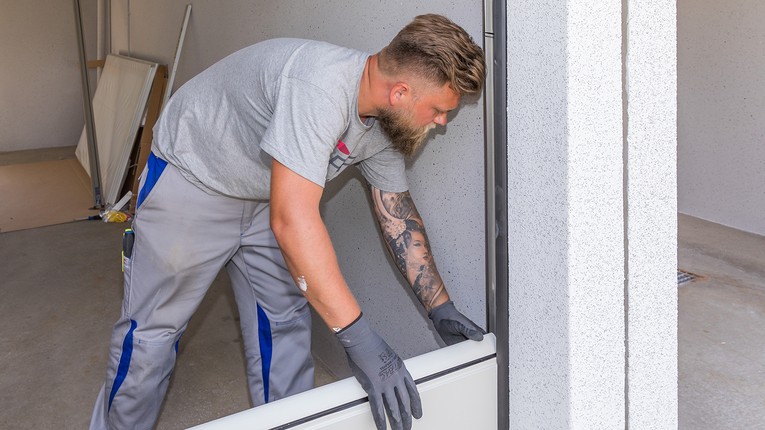 zapf_blog_beitragstitel_vorteile_tor Handwerker setzt Garagentorsegment in Führungsschiene ein.