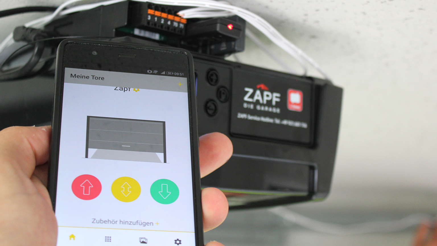 Smartphone steuert Garagentor über ZAPF App vor montiertem Antrieb.