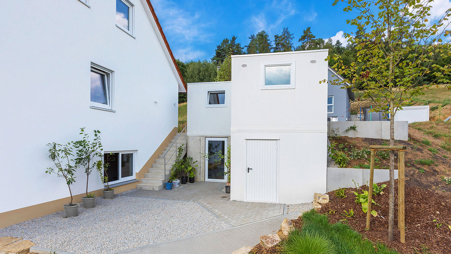 weiße Doppelstockgarage von ZAPF mit Fenster und Für am Hang