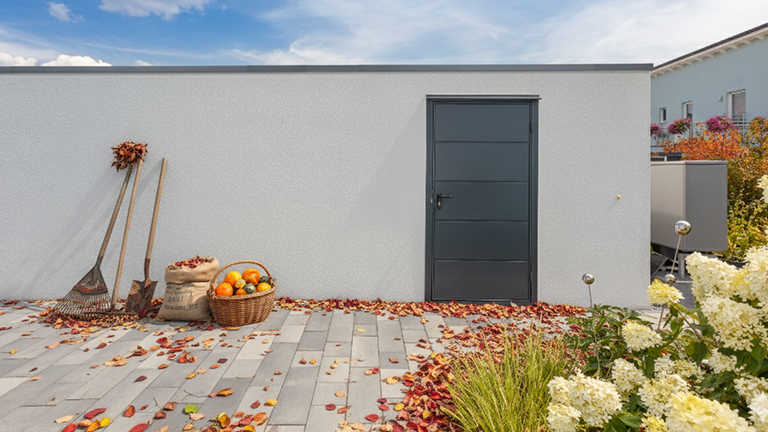 Herbstliche Betonfertiggarage mit Anbau und Tür