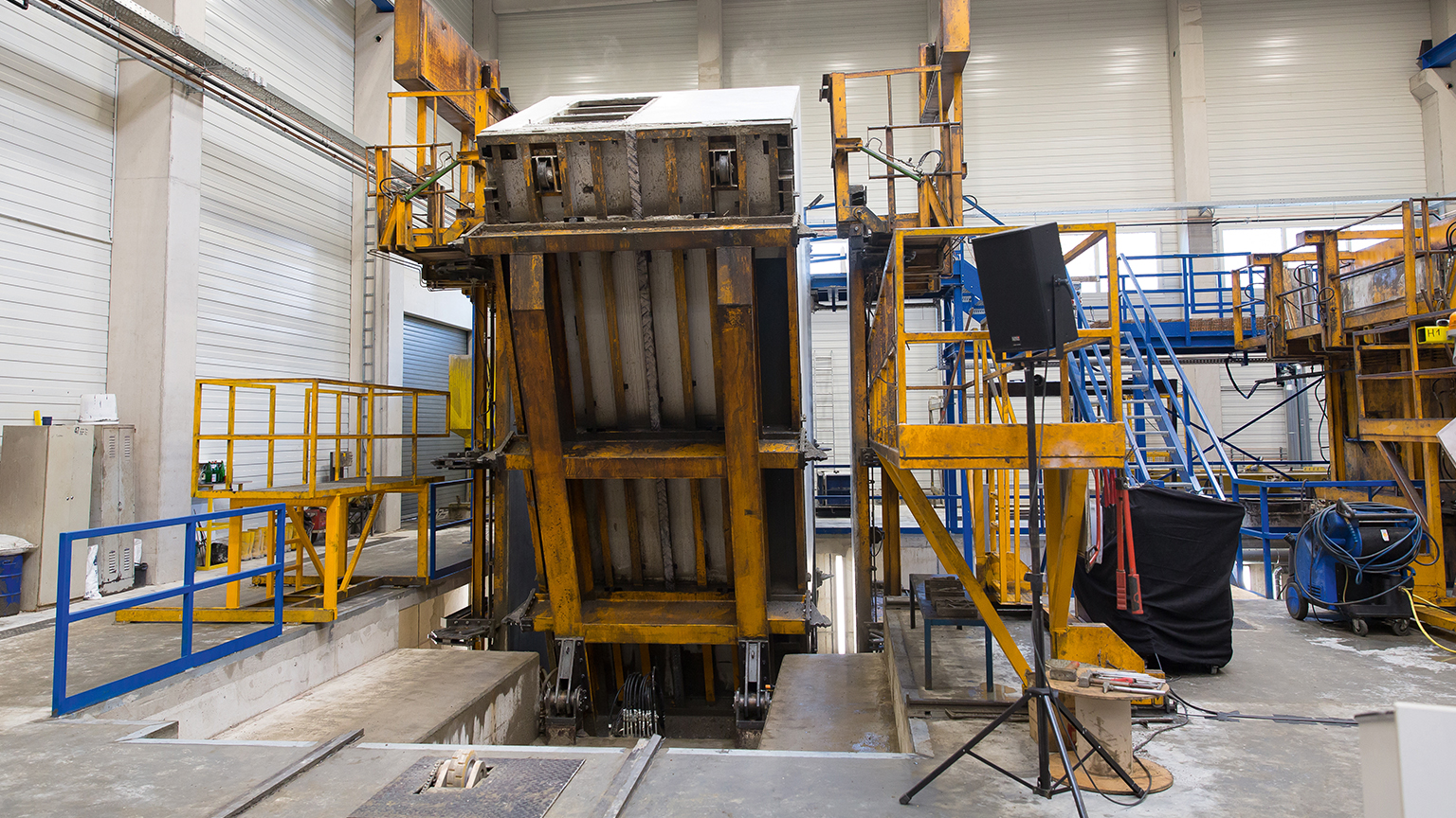 Produktionsanlage für Betonfertiggaragen im Werk Stationäre Kipp- und Schalungsanlage zur Herstellung von Betonfertiggaragen im Werk, massive Stahlkonstruktion mit Führungsschienen und Arbeitsbühnen in der Produktionshalle, ZAPF Qualität vom Hersteller ZAPF