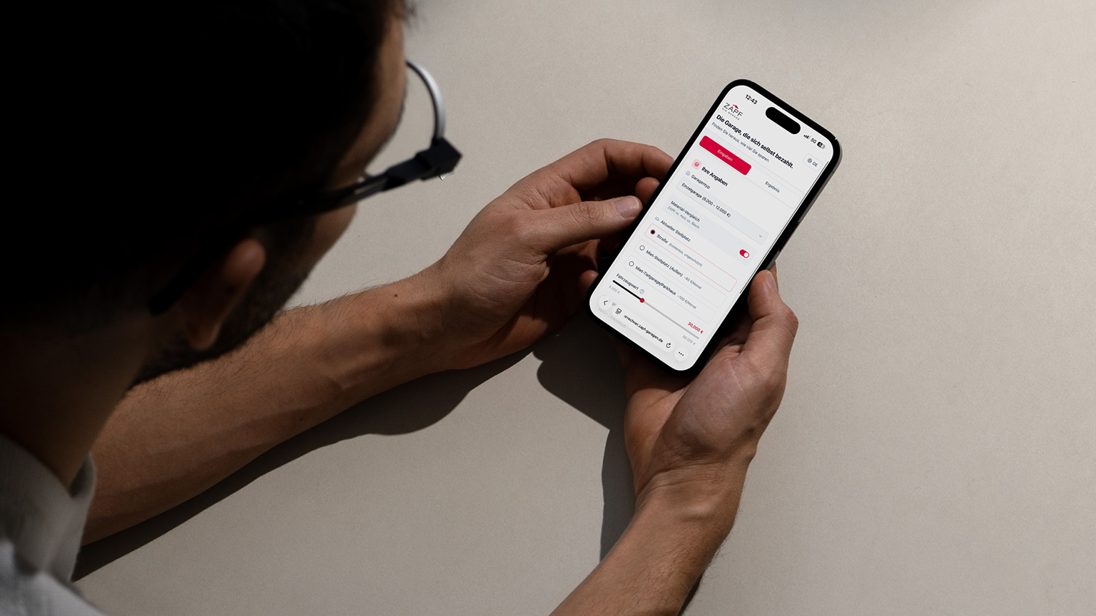 zapf-garagenrechner-smartphone-nutzung Mann nutzt ZAPF Sparrechner auf Smartphone zur Berechnung der Ersparnisse einer Betonfertiggarage