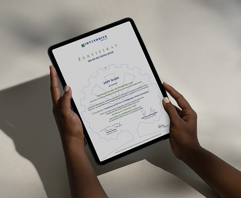 ISO 50001 Zertifikat der ZAPF GmbH auf einem Tablet in Händen gehalten
